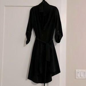 Black polyester shirt dress with drop skirt in back. Above knee in front.